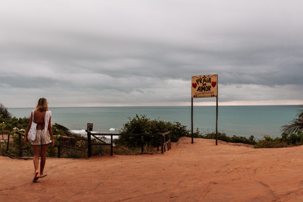 Emilly walking in front of the Praia do Amor sign in Pipa, Rio Grande do Norte