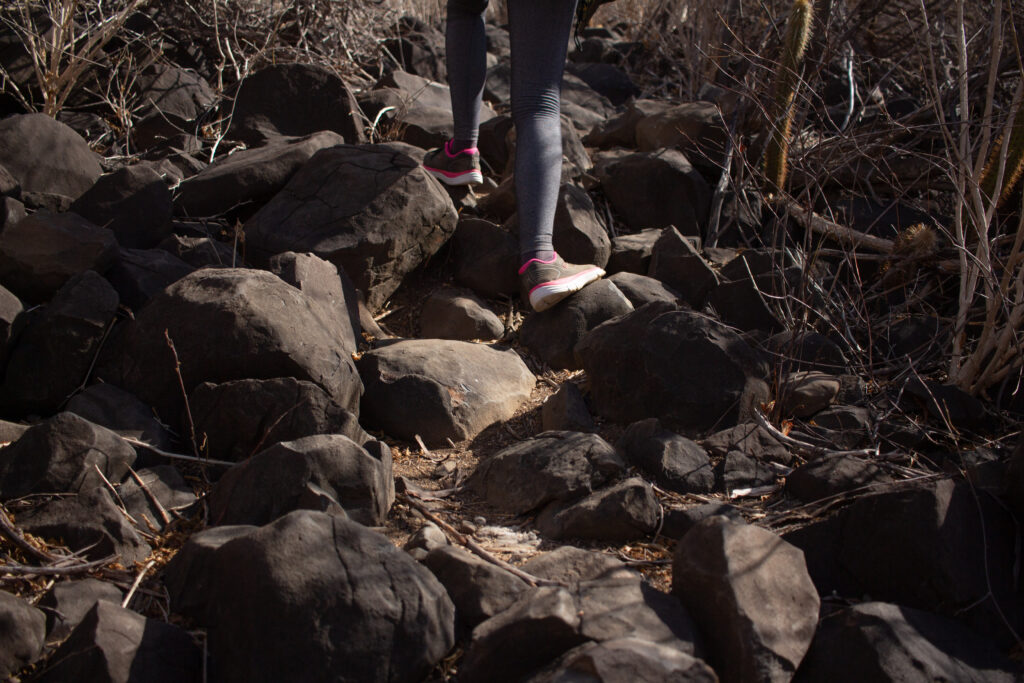 Feet climbing the rocky terrain of Cabugi Peak