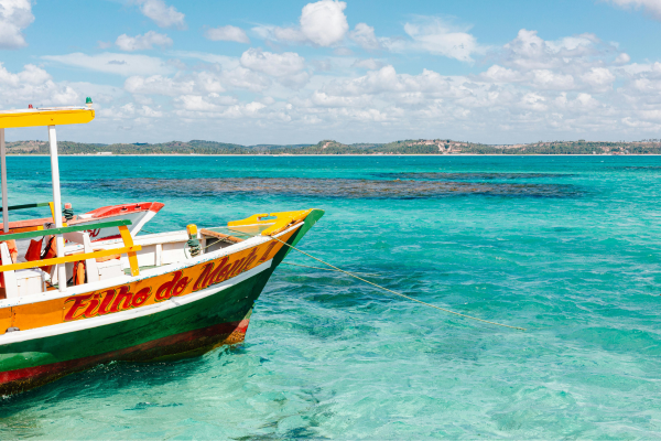 Traditional colorful boat in turquoise waters near São Miguel dos Milagres and Maragogi, Alagoas, Brazil, used for reef and natural pool tours.