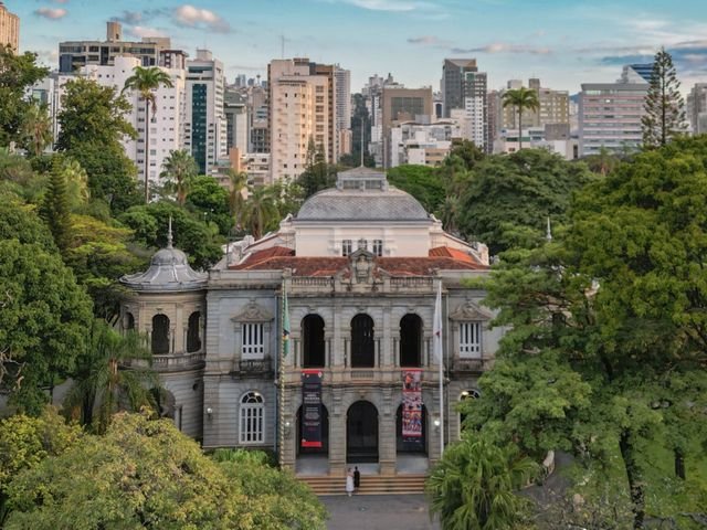 Elegant view of the Palace of Liberty surrounded by lush trees and modern skyline in Belo Horizonte, Brazil.